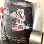 As Good as Dead by Holly Jackson novel next to duct tape and red marker.